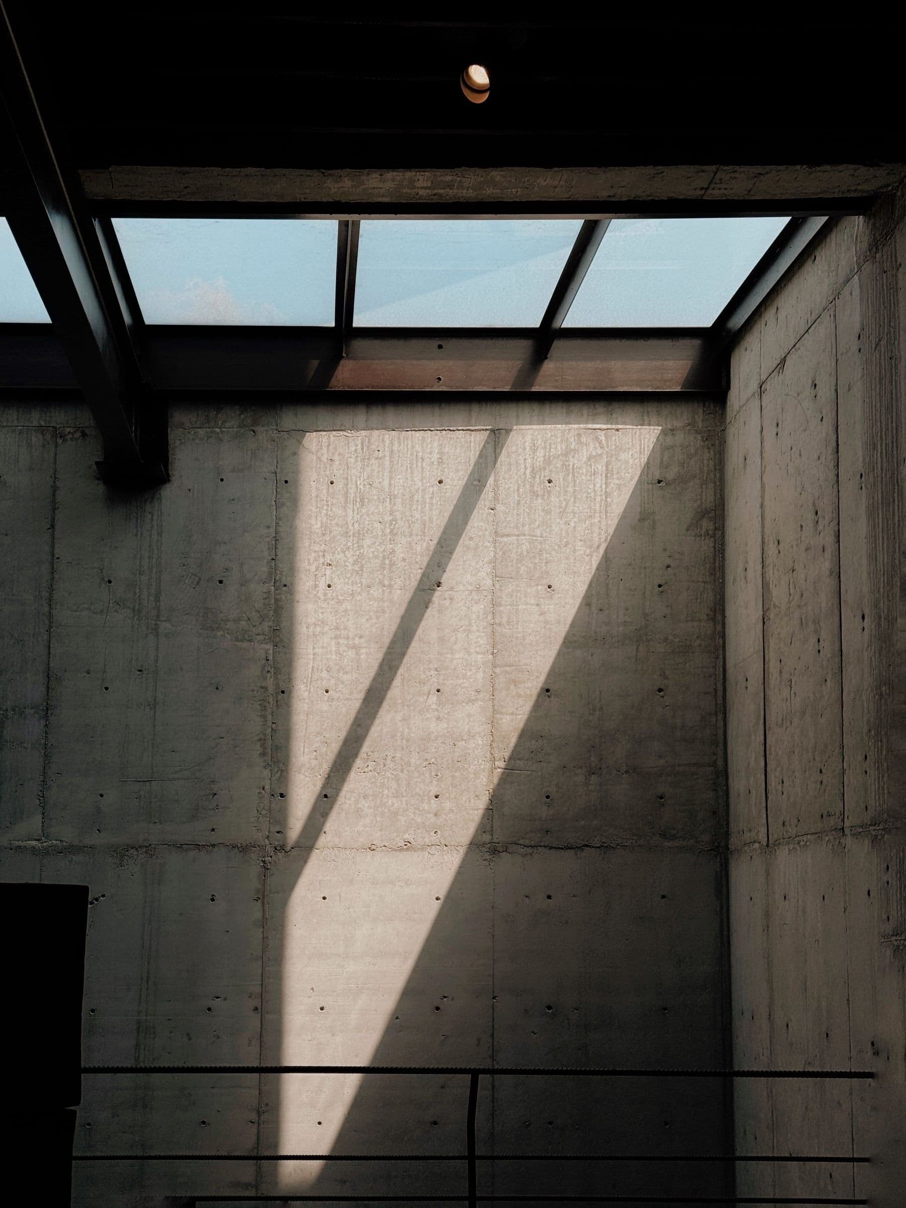 Daylight falling across a concrete stair at the studio, hard shadow